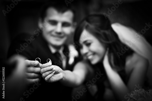 Blurred picture of happy wedding couple holding their engagement