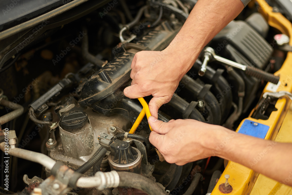 Mechanic use wrench for change spark plugs. Mechanic use wrench for change spark plugs.