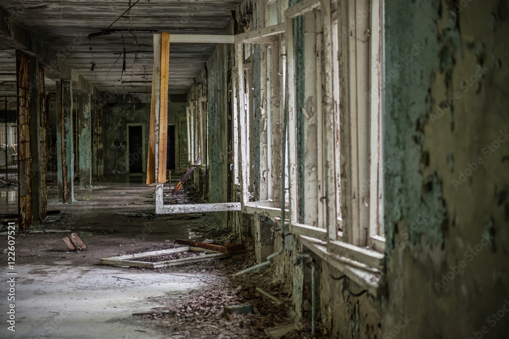 gloomy view of ruined hall with broken windows in Pripyat school