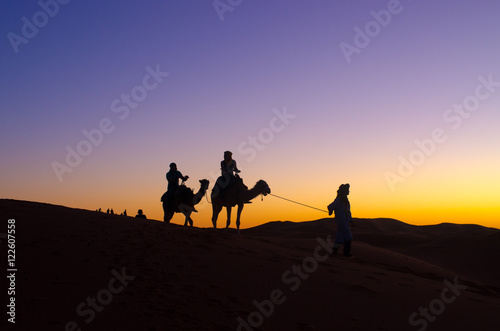 Sunset with caravan on Sahara desert
