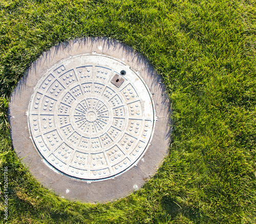 Closeup of a manhole and green grass