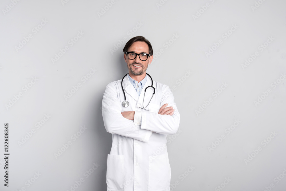 Smiling doctor standing on a grey background Smiling doctor standing on a grey background