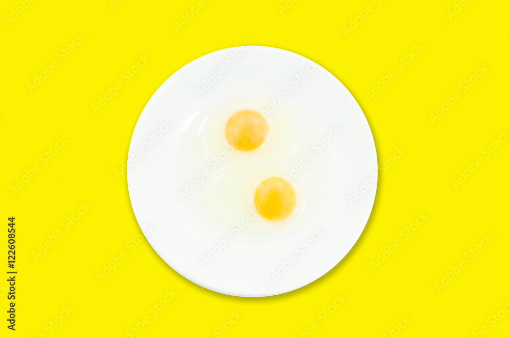 Raw egg yolks in a white bowl isolated on a yellow background, To prepare for a high protein diet has helped in the growth of a person's body Raw egg yolks in a white bowl isolated on a yellow background, To prepare for a high protein diet has helped in the growth of a person's body