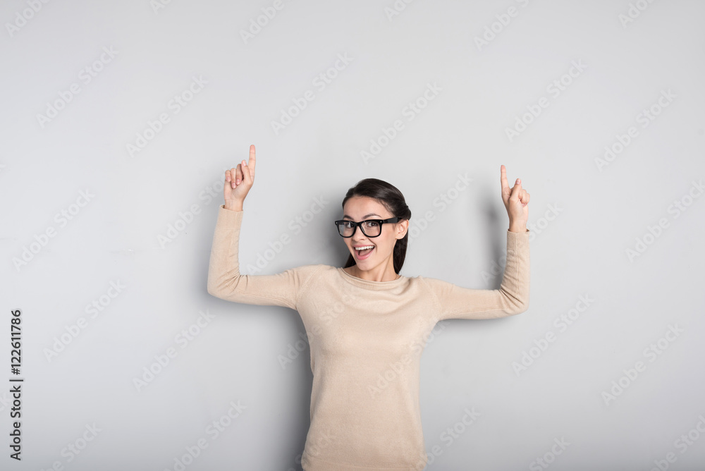 Joyful woman standing isolated on grey background