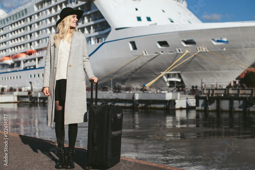 beautiful woman with a suitcase at sea cruise liner