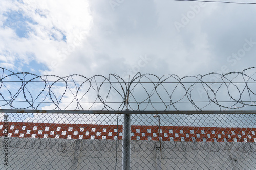 wall of prison with barbed wire background