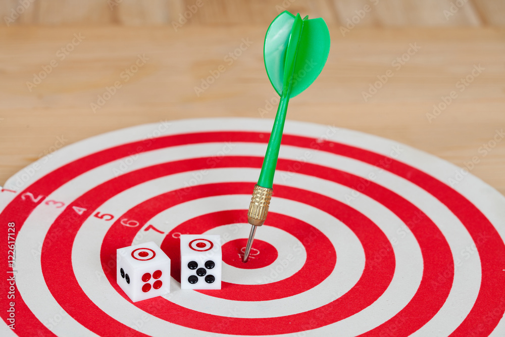 Dice on dart board with green dart arrow Dice on dart board with green dart arrow