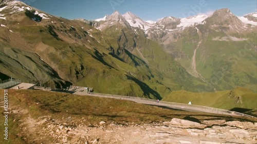 Highest mountains in Austria viewed from the top of Grossglockner alpine road, revealing Austrian flag, aerial footage