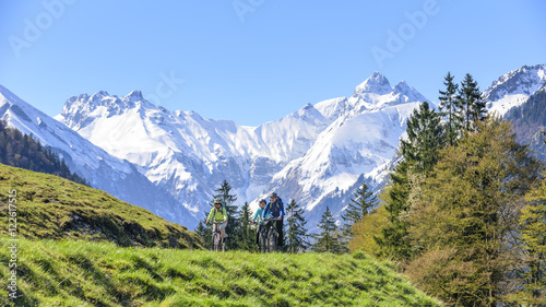 Drei Radfahrer im Allgäu vor frisch verschneiten Bergen © ARochau