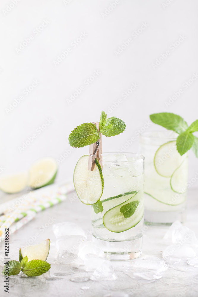 Cold cocktail with vodka, gin, soda, cucumbers, lime and mint with ice in the glass on the table Cold cocktail with vodka, gin, soda, cucumbers, lime and mint with ice in the glass on the table