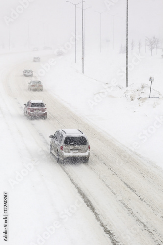 Traffic on a snow covered road, during a winter snowstorm.  Winnipeg, Manitoba, Canada. photo