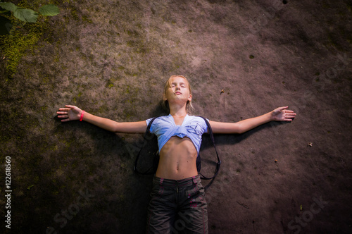 Obraz na plátne Girl lies on a huge stone