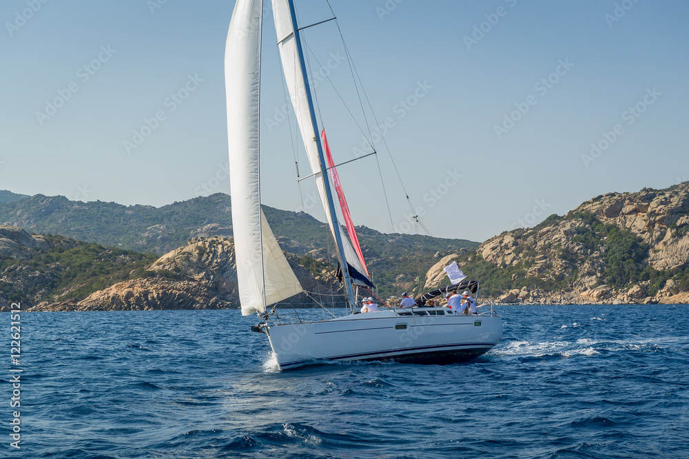 Cruising sailboat sailing near Sardinia island shores. Cruising sailboat sailing near Sardinia island shores.