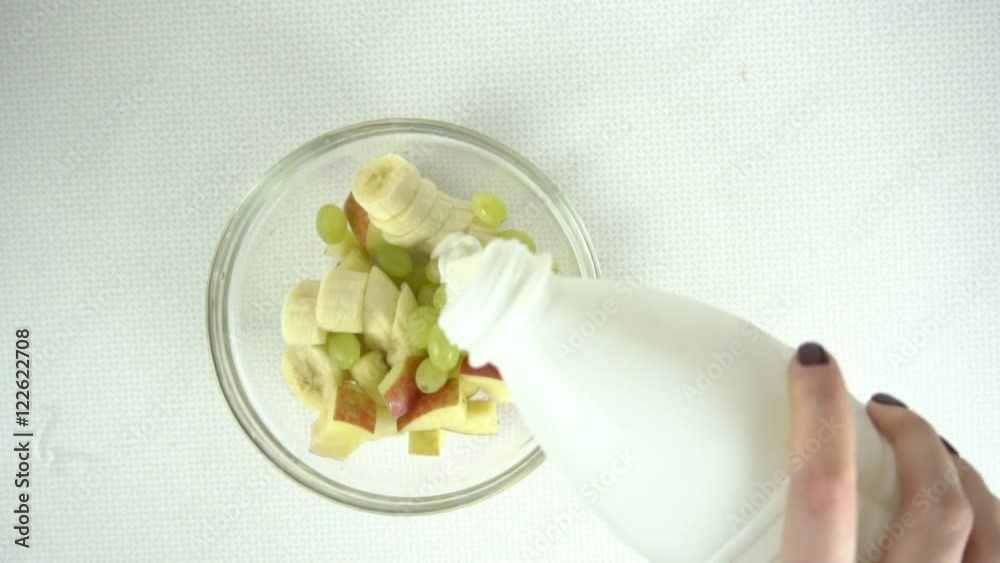 Putting yogurt into fruit salad, slow motion Putting yogurt into fruit salad, slow motion
