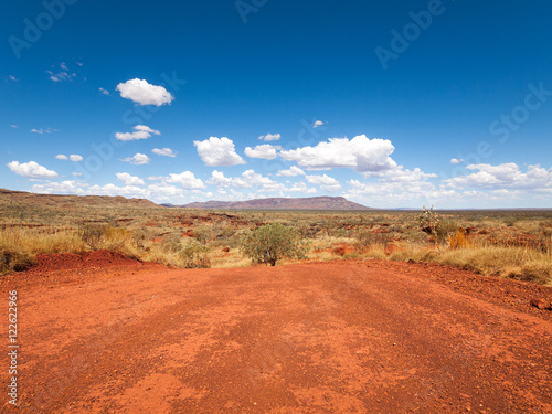 a wide shot of the harsh arid red landscape of the australian outback bush, with a vivid blue sky backdrop photo