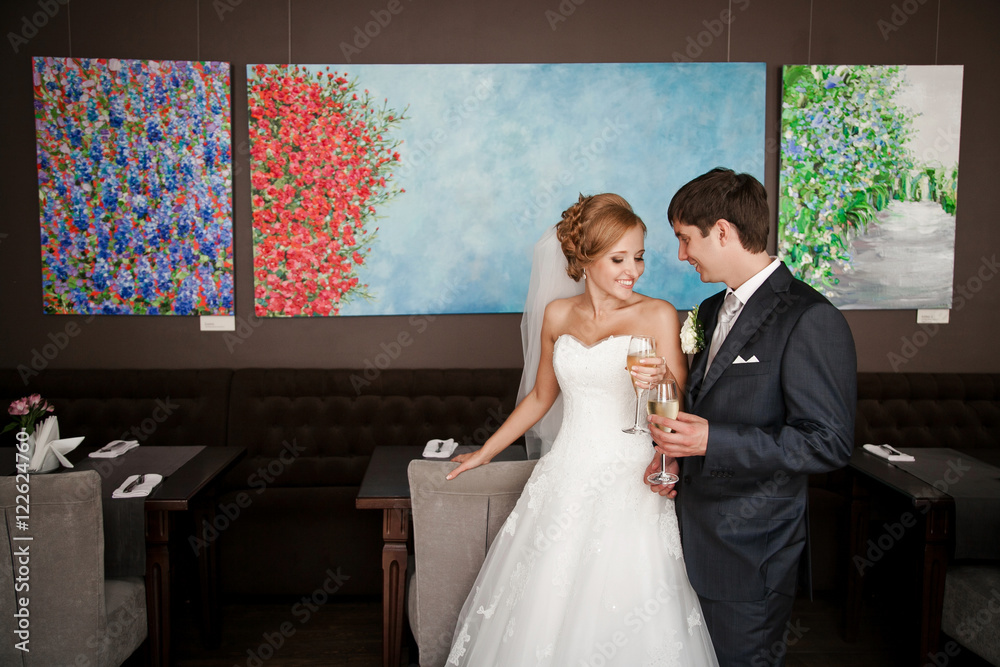 Red-haired bride holds glass with champagne 
