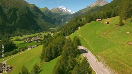 Flying towards alpine village Heiligenblut on sunny summer day, popular tourist destination in Austria