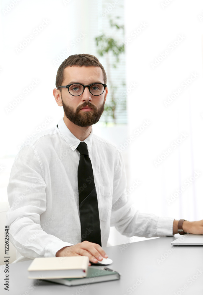 Businessman sitting at table in office Businessman sitting at table in office