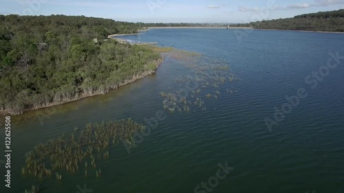 Forward flight along the coastline of Lysterfield Lake on bright sunny day. Melbourne, Victoria, Australia. photo