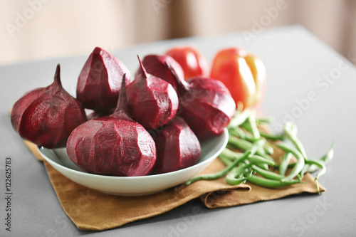 Plate with fresh beetroot on table