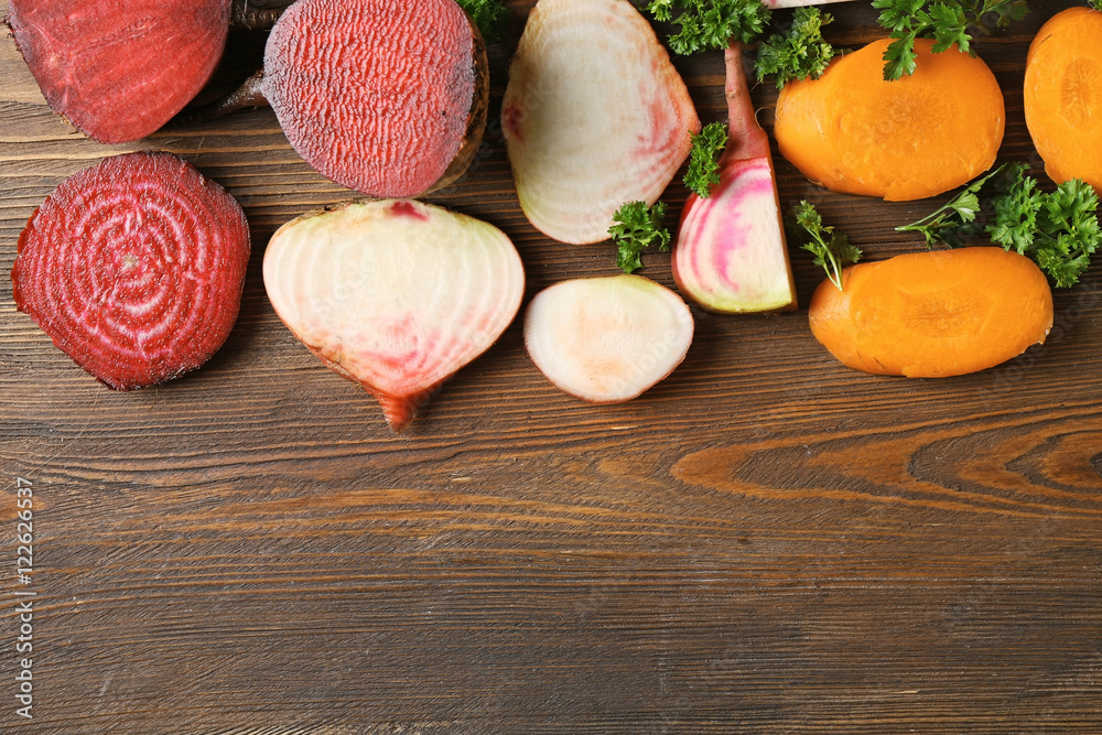 Fresh young sliced beets and carrots with parsley on wooden background Fresh young sliced beets and carrots with parsley on wooden background