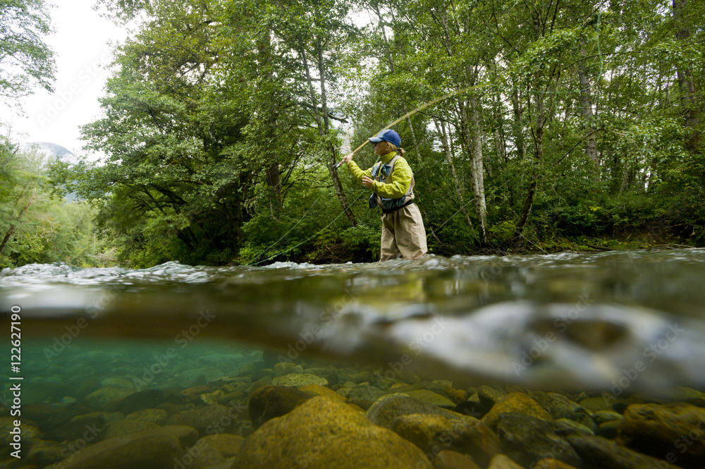 A young woman fly-fishing for trout on the Saloompt River, Bella Coola,  British Columbia Stock Photo