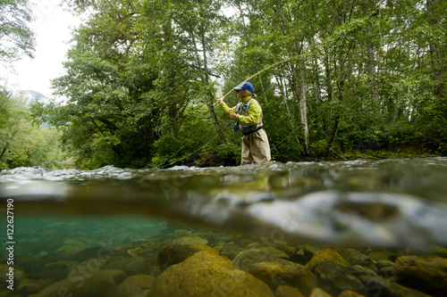 A young woman fly-fishing for trout on the Saloompt River, Bella Coola, British Columbia photo