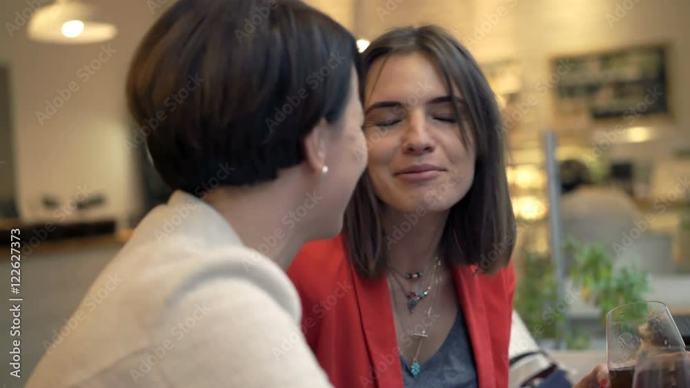 Two, happy pretty girlfriends with beverages talking in cafe
Two, happy pretty girlfriends with beverages talking in cafe
