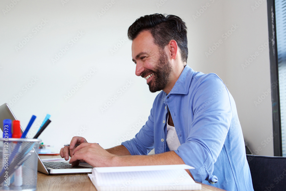 Smiling mature business man working at his office Smiling mature business man working at his office
