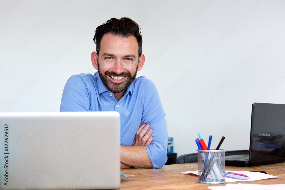 Happy mature business man sitting at his office desk Happy mature business man sitting at his office desk