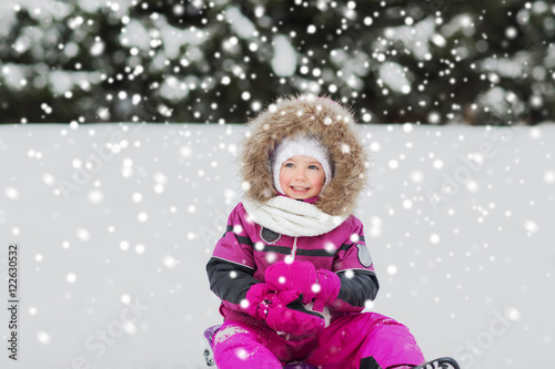 happy little kid on sled outdoors in winter