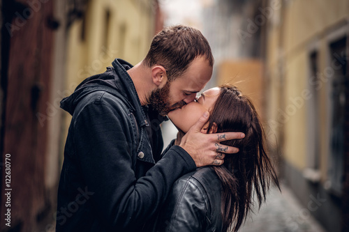 Positive bearded male kissing cute brunette female.