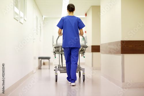 nurse carrying hospital gurney to emergency room photo