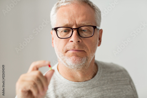 close up of senior man taking medicine pill