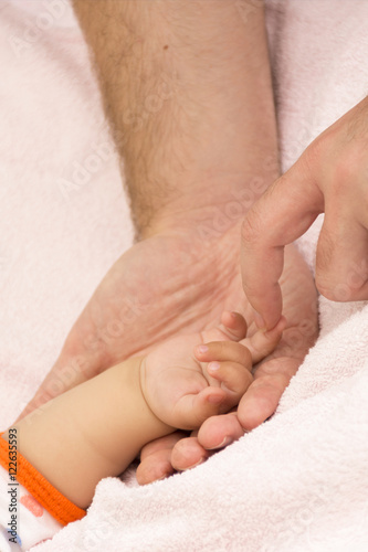baby's hand and father's arms