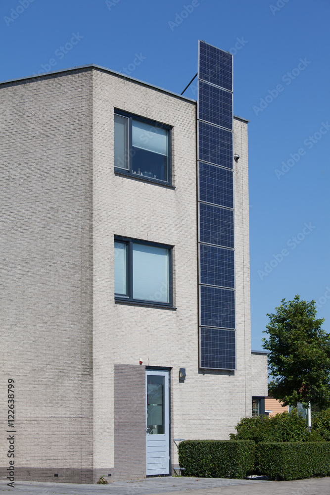 Modern house with solar panels on the wall for alternative energ