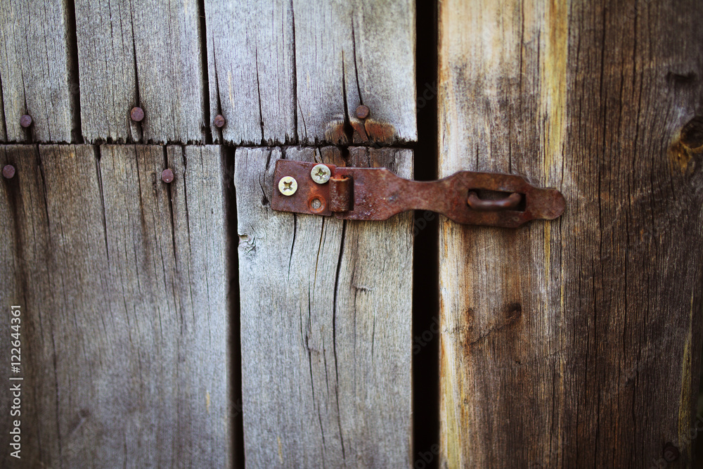 Old rusty lock hanging on the gray wooden door. Old rusty lock hanging on the gray wooden door.