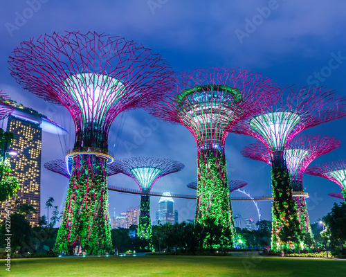 Futuristic view of amazing illumination at Garden by the Bay in Singapore. Night light show at Supertree Groveis is main Marina Bay Sands district tourist attraction