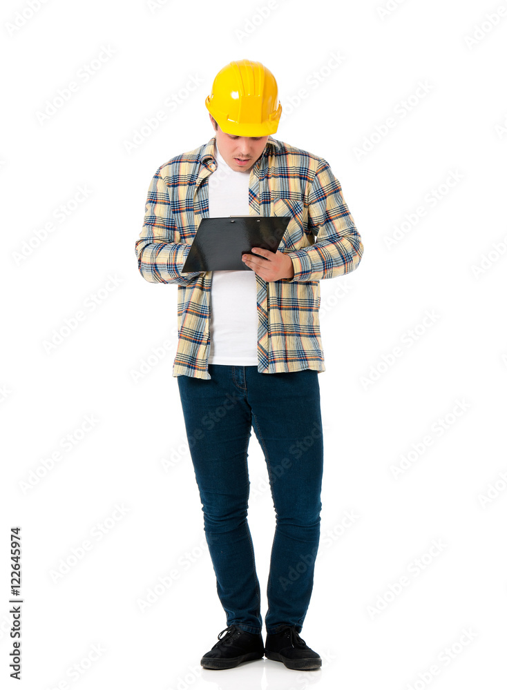 Full lenght portrait of a young architect with yellow hard hat. An engineer or foreman holding clipboard. Young construction worker or businessman wearing helmet, isolated on white background. Full lenght portrait of a young architect with yellow hard hat. An engineer or foreman holding clipboard. Young construction worker or businessman wearing helmet, isolated on white background.