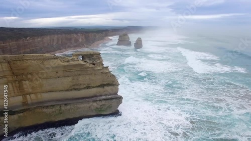 Round cinematic movement around 12 Apostles lookout revealing the main apostles cluster. Great Ocean Road, Victoria, Australia.