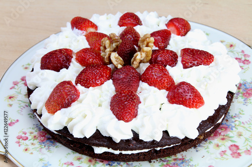 Homemade Chocolate cake, whipped cream, strawberries and walnuts.