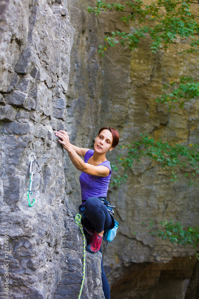 The girl climbs the rock.