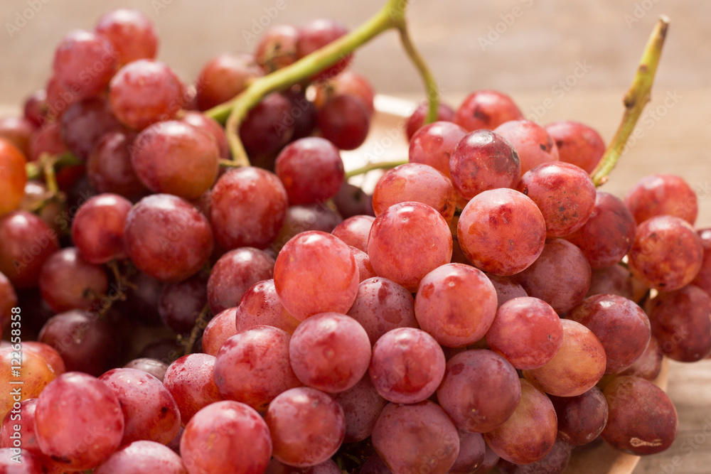 Red grapes on old wooden table,closeup background