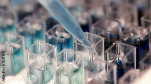 Sample filling in spectrophotometer cuvettes for analysis, close up. Slow motion