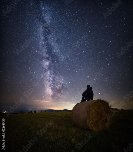 Person on hay bale watching stars  photo