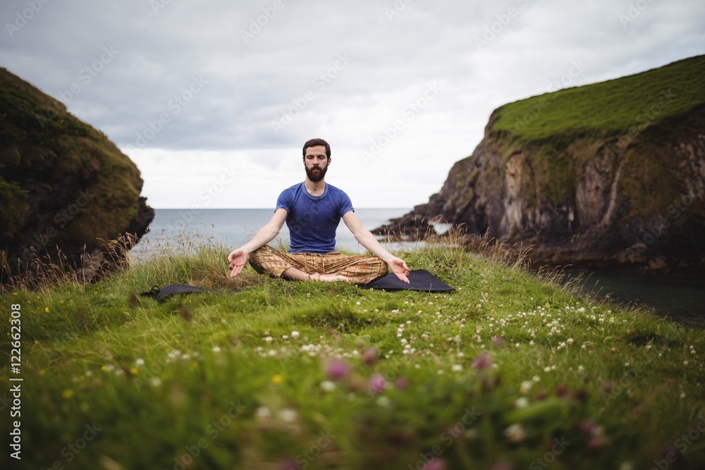Man practicing yoga while sitting outdoors Man practicing yoga while sitting outdoors