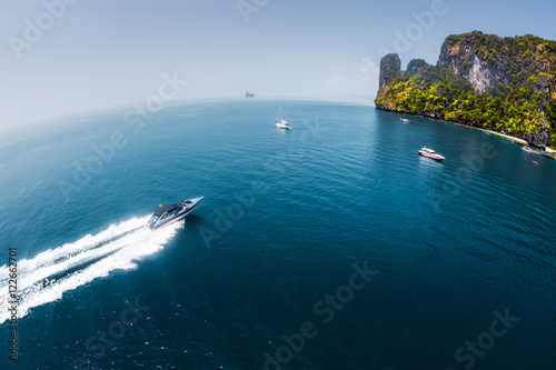 View of the island in Andaman sea with speedboat in a clear water, Thailand photo