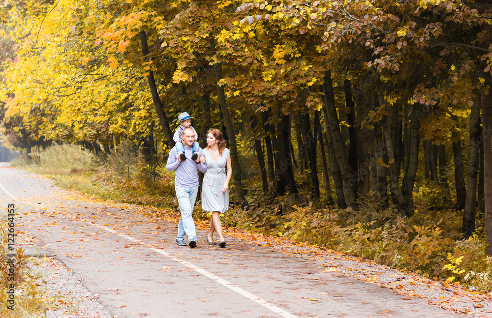 Fototapeta premium Happy family walking in autumn park