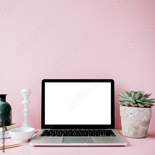 Laptop with blank screen on table with proteus flower and decoration