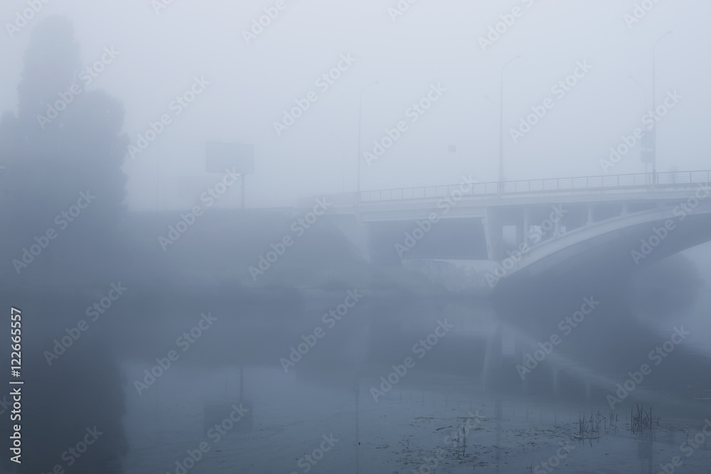 Dense fog in the city. The bridge is almost not visible. Early morning in Kyiv 